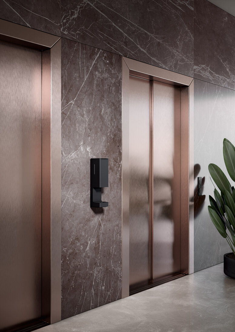 HEWI SENSORIC disinfectant dispenser wall model A touch-free disinfectant dispenser is installed on the wall between two elevator doors